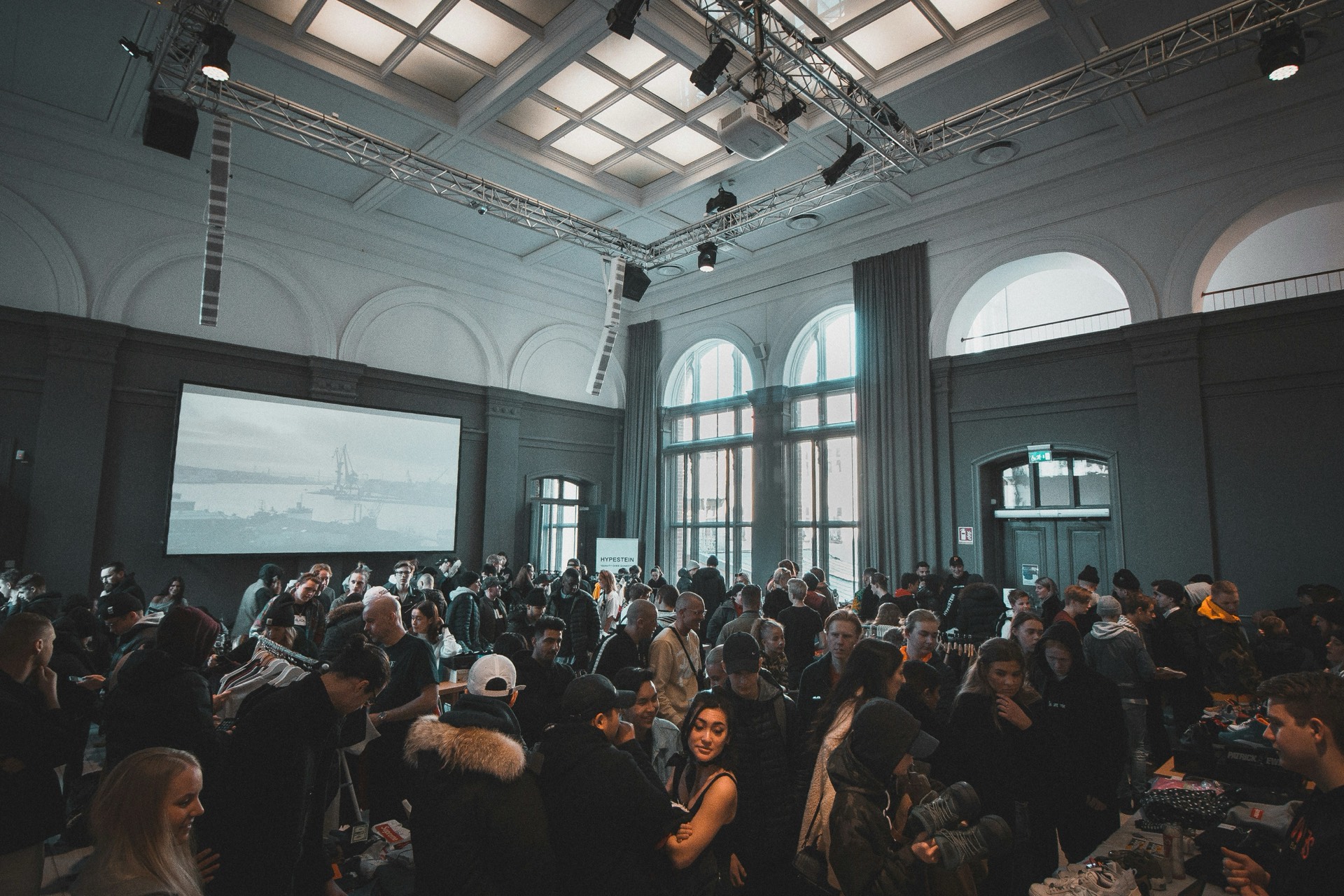 A hall full of people mingling at an evening event